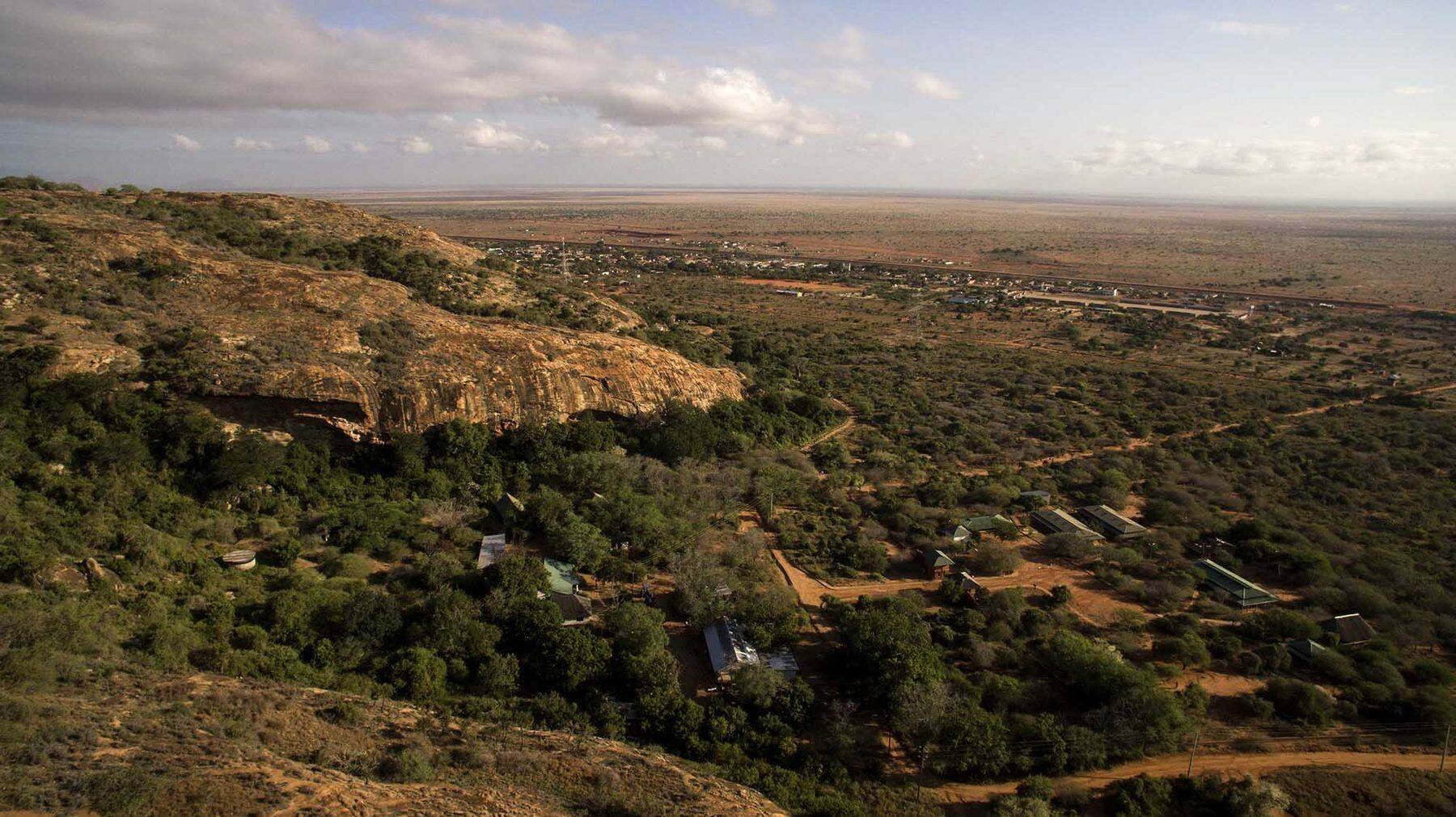 Aerial of a remote tented camp in escarpment landscape